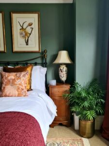 Designer Period Properties, Dark Green Bedroom With Brass Bed, Gold Cushions, Teak Bedside Table And Antique Table Lamps.