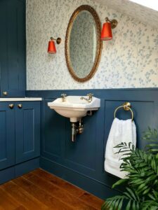Bathroom and utility room with blue panelling and botanical wallpaper
